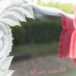 Gebeeldhouwde roos op grafsteen