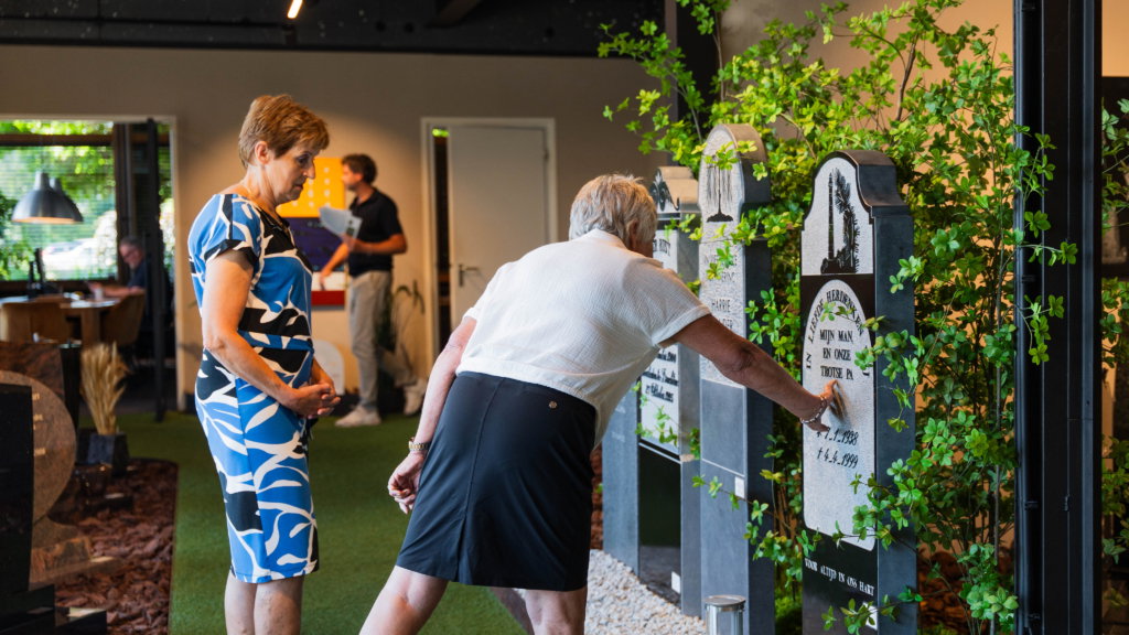 Bezoekers bekijken van dichtbij de grafmonumenten in de showroom
